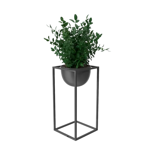 Artificial boxwood plant in a black bowl on a tall metal stand, angled view